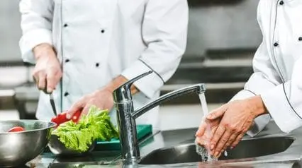 two chefs practicing proper food hygiene measures