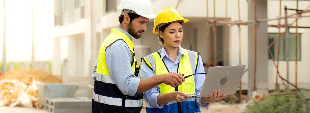 trabajadores de la construcción que utilizan un programa informático de gestión de documentos de construcción sobre el terreno