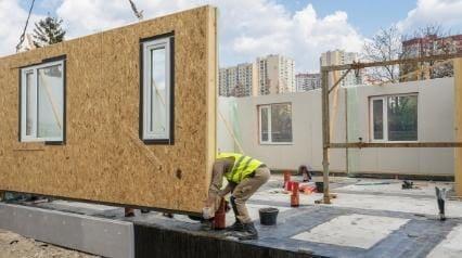 trabajadores de la construcción modular montando un edificio prefabricado