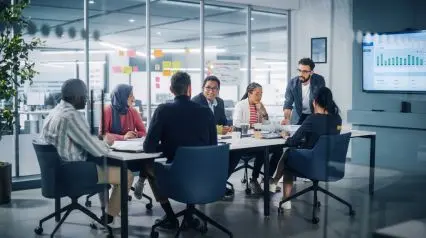 trabajadores en una sala de reuniones evaluando las prácticas de gestión de la organización