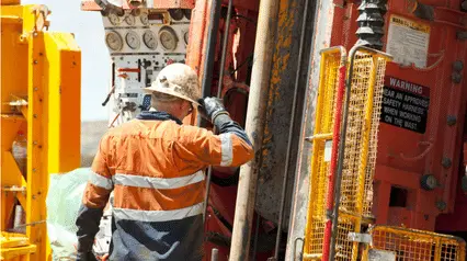 Bauarbeiter, der auf einer Baustelle mit einem Kernbohrer bohrt