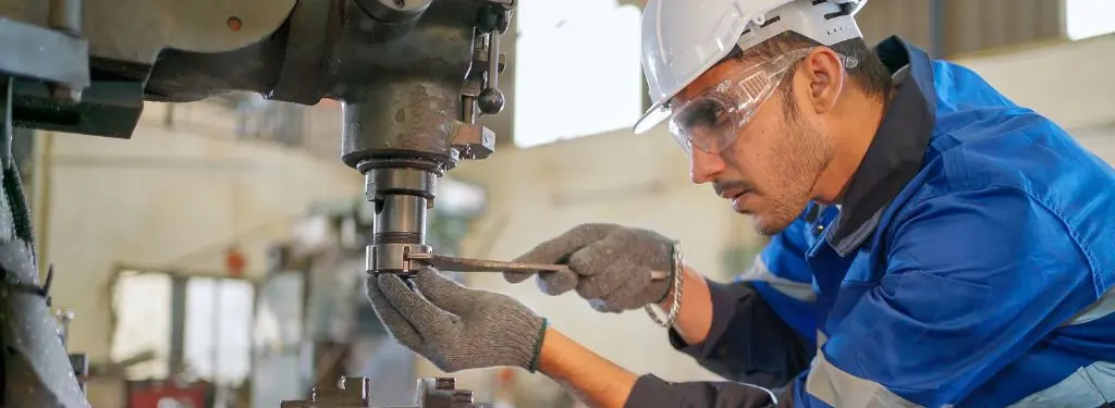 a technician fixing a machine as guided by a manufacturing asset management software