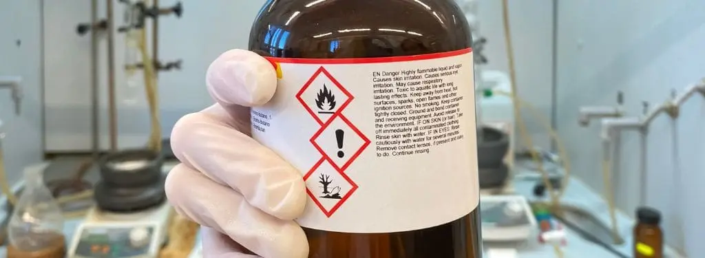 a chemical bottle with a safety data sheet as a safety requirement being inspected using a safety data sheet software|3E Protect Safety Data Sheet Software|BackPack by Chemwatch Safety Data Sheet Software|Labelmaster Safety Data Sheet Software|SpheraCloud Safety Data Sheet Software|VelocityEHS Safety Data Sheet Software