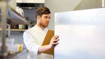 personal de cocina inspeccionando el almacenamiento de alimentos en un restaurante