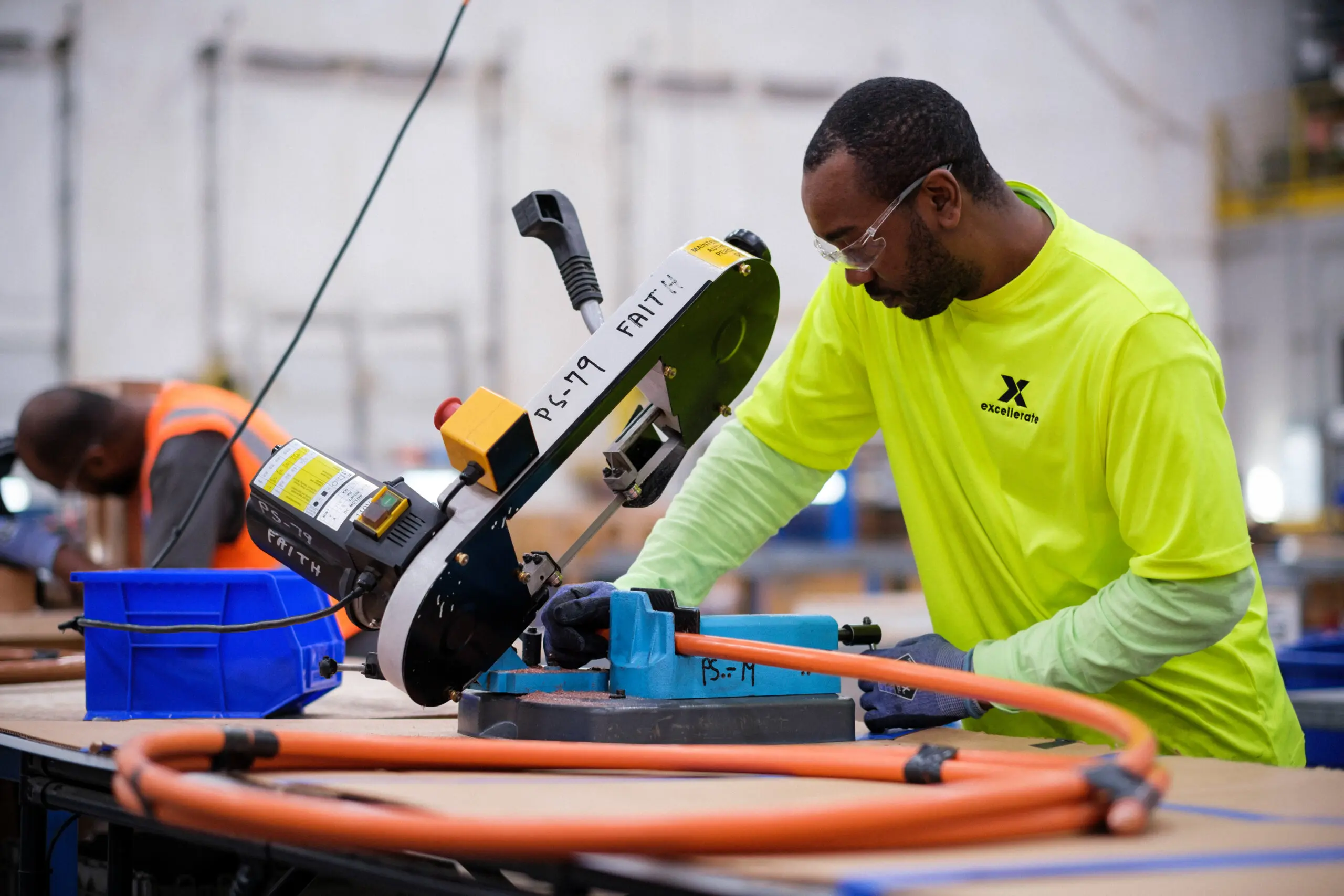 a manufacturing worker safely cutting a wire with