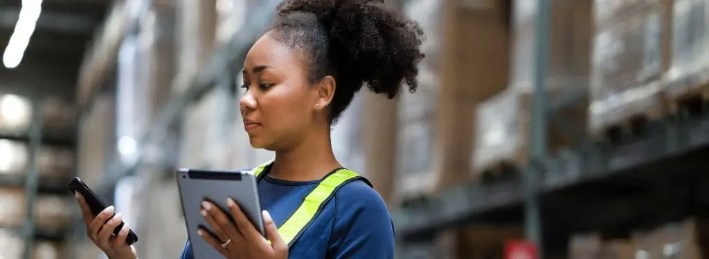 a warehouse manager checking stocks for distribution using a distribution app on a tablet|Bautomate Distributor App|Nautical Distributor App|Sendcloud Distributor App|ShipStation Distributor App|Wix Enterprise Distributor App|Zoho Commerce Distributor App