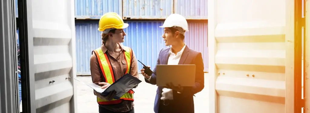 two shipment supervisors using container tracking software on mobile devices at work