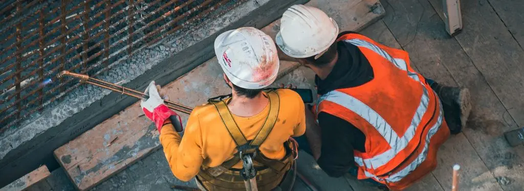 two construction workers on site during a training with the help of a construction training software