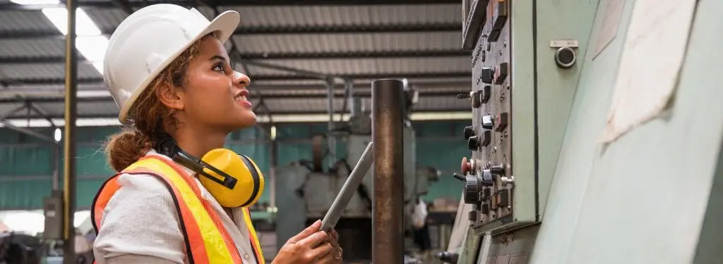 un trabajador industrial inspecciona equipos utilizando un software de gestión de instalaciones empresariales en una tableta|eFACiLiTY|Facilio|IBM Tririga|iLab by Agilent|QuickFMS|Ramco