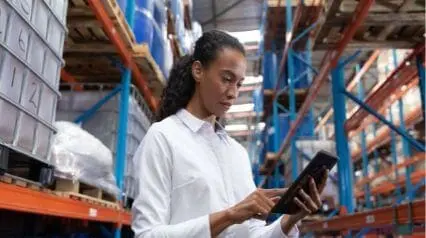 mujer que utiliza la tableta y practica la gestión de almacenes